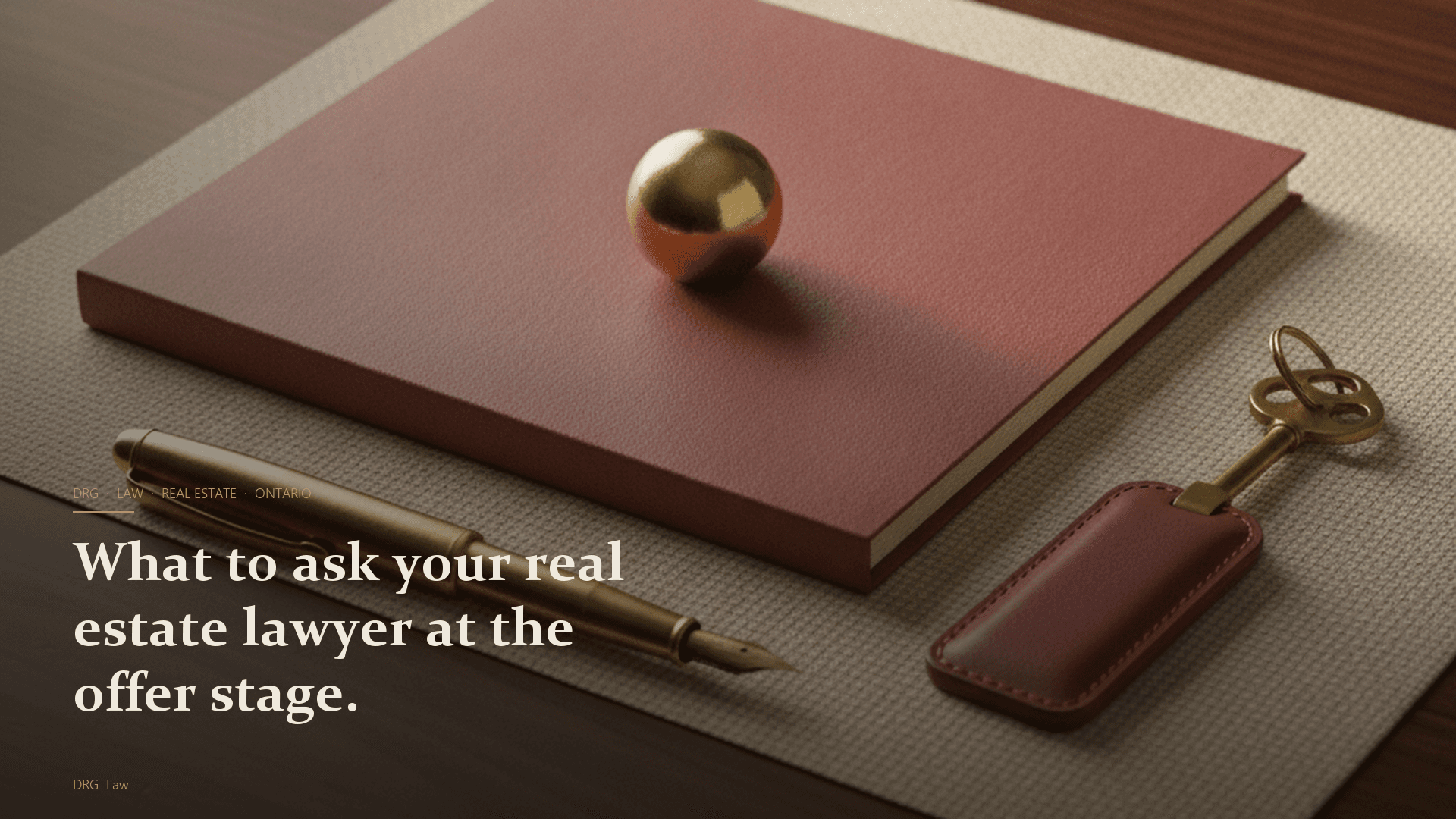 A brass-tipped fountain pen beside a closed real estate file folder with a small brass paperweight on top, a brass house key on an oxblood leather fob on a cream linen mat, walnut desk surface in warm morning side-light
