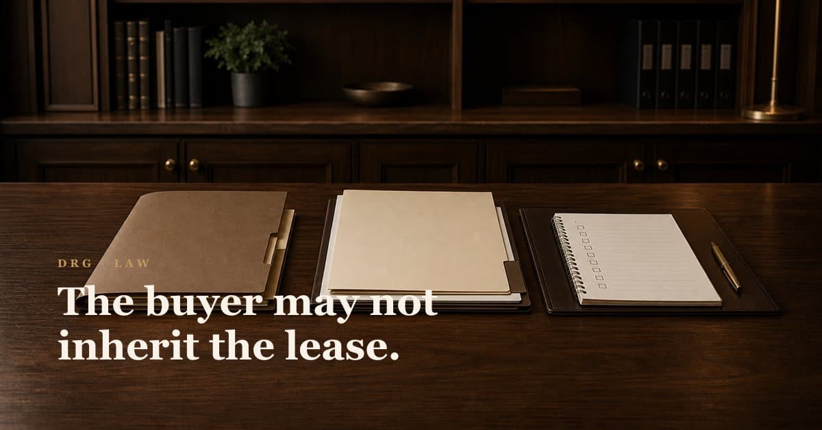 A brass key on an oxblood leather fob beside legal papers on a walnut desk